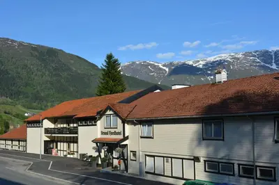 a group of buildings with mountains in the background at Strand Fjordhotel in Ulvik