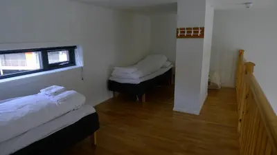 a small room with two beds and a window at Hordatun Hotel in Røldal