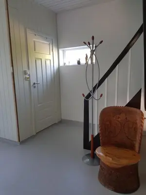 a room with a staircase with a chair and a door at Family Room in Modern House in Eide