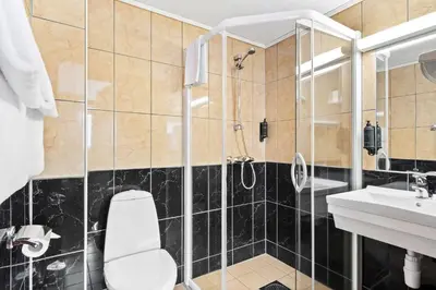 a bathroom with a shower and a toilet and a sink at Best Western Laegreid Hotell in Sogndal