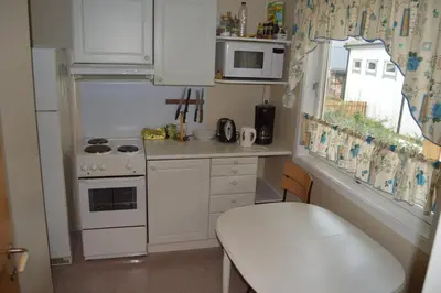 a small kitchen with white appliances and a table at Villa Åndalsnes in Åndalsnes