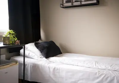 a bed with a black pillow on it in a room at Ågotnes Motell in Ågotnes