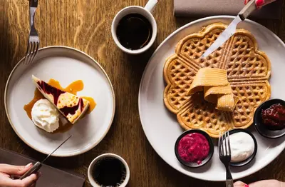 a table with a plate of waffles and a plate of food at Ågotnes Motell in Ågotnes