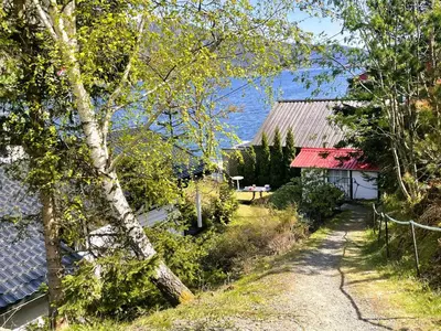 a path leading to a house with a red roof at Der Fjordtraum in Balestrand direkt am Wasser in Balestrand