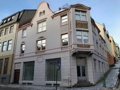 a pink building on the side of a street at Kirkegata 4 in Ålesund