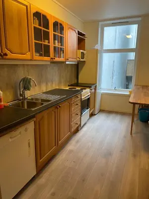 a kitchen with wooden cabinets and a sink and a window at Kirkegata 4 in Ålesund