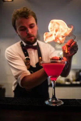a man is stirring a drink in a cocktail at Grande Fjord Hotel in Geiranger