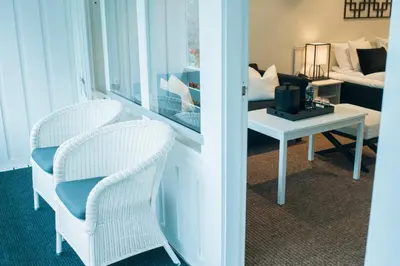 a living room with two chairs and a table at Grande Fjord Hotel in Geiranger