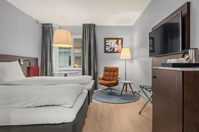 a hotel room with a bed and a chair at Quality Hotel Ålesund in Ålesund