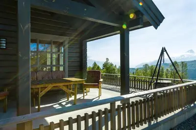 a house with a deck with a table and chairs at Gladheim in Stranda