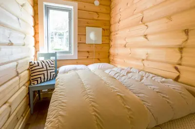 a bed in a wooden room with a window at Gladheim in Stranda