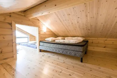 a bedroom in a log cabin with a bed in it at Gladheim in Stranda
