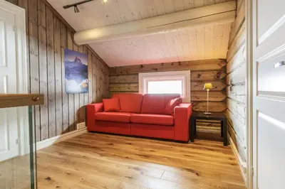 a red couch in a room with wood paneling at Lake View Apartment 4 bedrooms in Brunstad