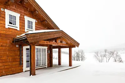 a wooden cabin in the snow with snow on it at Lake View Apartment 4 bedrooms in Brunstad