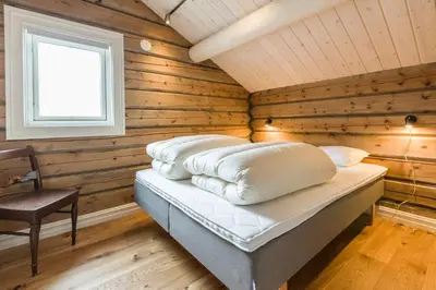 a bedroom with wooden walls and a bed with pillows at Lake View Apartment 4 bedrooms in Brunstad
