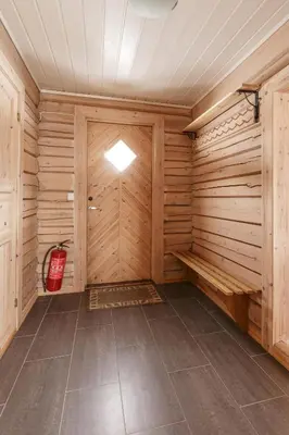 a sauna with wood paneling and a red fire extinguisher at Røde Kors in Brunstad