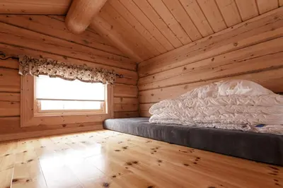 a bedroom with a bed in a log cabin at Røde Kors in Brunstad