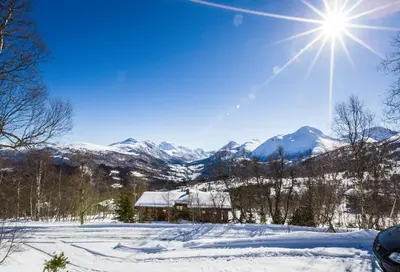 a winter view of a mountain with the sun in the sky at Sjåfram in Stranda