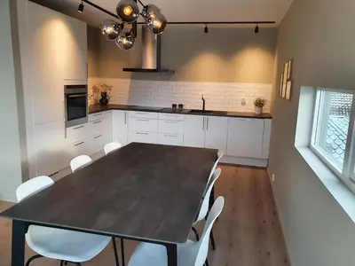 a kitchen with a black table and white chairs at Veversmauet Apartments in Bergen