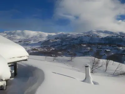 a snow covered view of a town in the distance at Haukeli Mountain Cabin in Vågsli