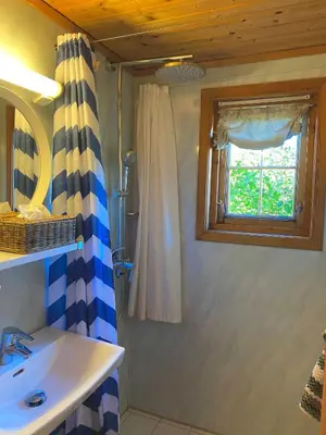 a bathroom with a sink and a shower and a window at Haukeli Mountain Cabin in Vågsli