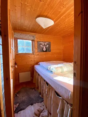 a bedroom with a bed in a wooden cabin at Haukeli Mountain Cabin in Vågsli