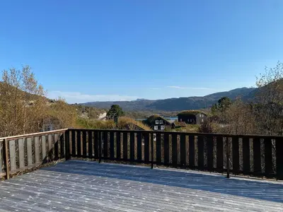 a wooden deck with a view of the mountains at Haukeli Mountain Cabin in Vågsli
