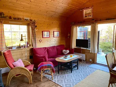 a living room with a red couch and a table at Haukeli Mountain Cabin in Vågsli