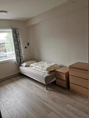 a small bedroom with a bed and a window at Moldefjord Hostel in Molde