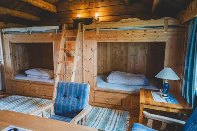 two bunk beds in a cabin with a table and a chair at Putten Seter in Høvringen