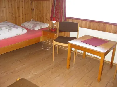 a bedroom with a bed and a desk and a table at Putten Seter in Høvringen