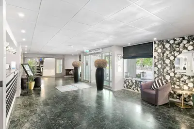 a lobby with a couch and a television in a building at Kinsarvik Fjordhotel, BW Signature Collection in Kinsarvik