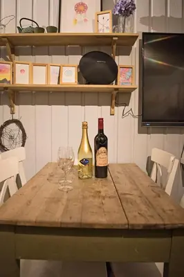 a table with two bottles of wine and a glass at Koselig Hytte i Hemsedal with outdoor Sauna in Hemsedal