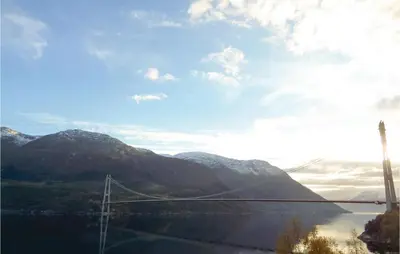 a bridge over a body of water with mountains at 3 Bedroom Nice Home In Vallavik in Vangsbygd