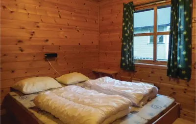 a bedroom with two beds in a log cabin at 3 Bedroom Nice Home In Vallavik in Vangsbygd
