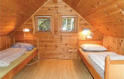 a log cabin with two beds in it at Gorgeous Home In Vallavik With Wifi in Vangsbygd