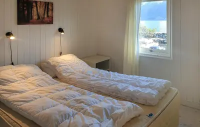 two unmade beds in a room with a window at 2 Bedroom Cozy Home In Vallavik in Vangsbygd