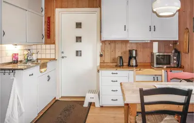 a small kitchen with white cabinets and a table at Three-Bedroom Holiday Home In Sjusjoen in Sjusjøen