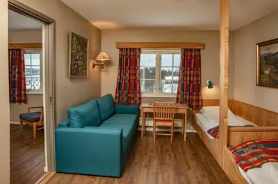 a bedroom with a couch and a bed and a table at Venabu Fjellhotell in Venabygd