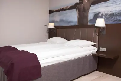 a bed in a room with a picture on the wall at Quality Hotel Waterfront in Ålesund