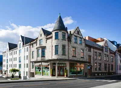a large stone building with a turret on a street at Quality Hotel Waterfront in Ålesund