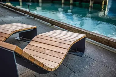 a wooden bench next to a pool of water at Quality Hotel Waterfront in Ålesund