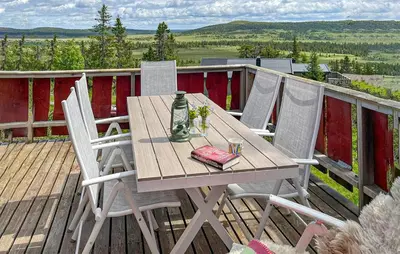 a wooden table and chairs on a deck at Three-Bedroom Holiday Home In Sjusjoen in Sjusjøen