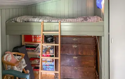a bedroom with a bunk bed with a ladder and a desk at Three-Bedroom Holiday Home In Sjusjoen in Sjusjøen