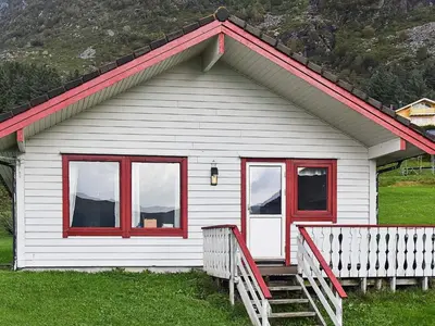 a white house with red windows and a porch at 7 person holiday home in Selje-By Traum in Selje
