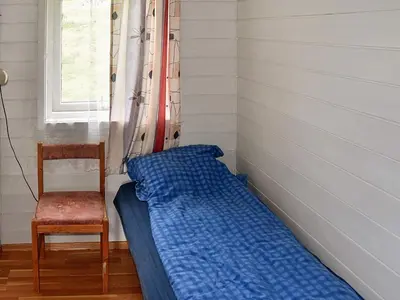 a bed in a room with a chair and a window at 7 person holiday home in Selje-By Traum in Selje