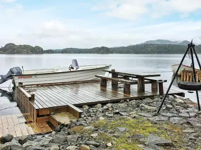 a boat sitting on a dock on a lake at 8 person holiday home in FINNÅS in Vordnes