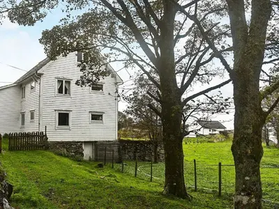 an old white house in a field with a tree at 8 person holiday home in FINNÅS in Vordnes