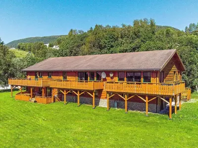 a large wooden house with a large deck at 5 person holiday home in EIDSVÅG in Eidsvåg