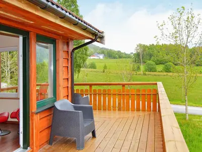 a porch of a house with a table and a chair at 6 person holiday home in EIDSVÅG in Eidsvåg